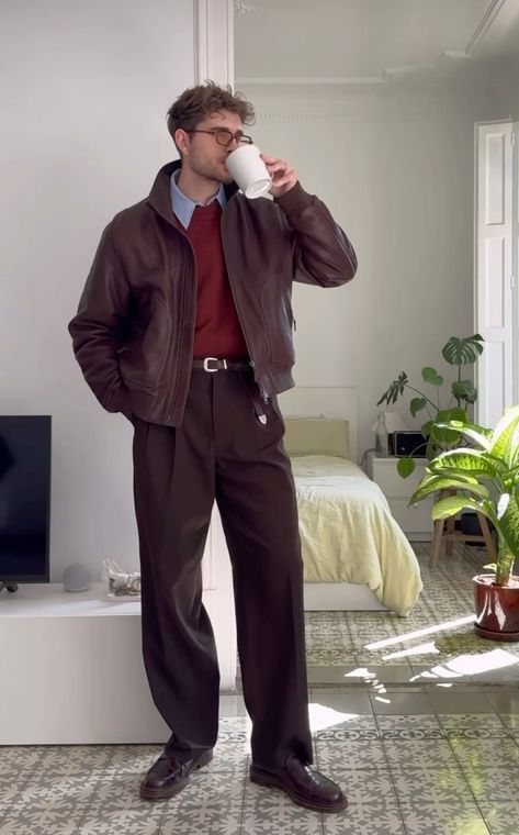 A man wearing a red sweater, with brown pants and loafers