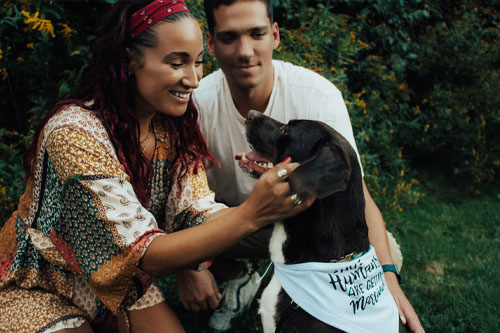 Couple with dog by flowers