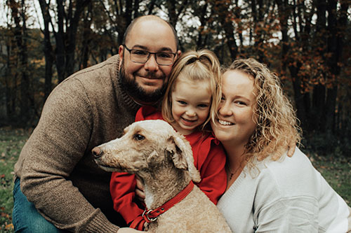 Family smiling with dog