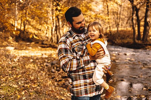 Father and daughter in fall scene with water