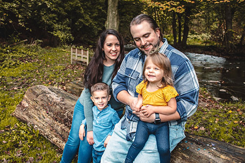 Family on log by water