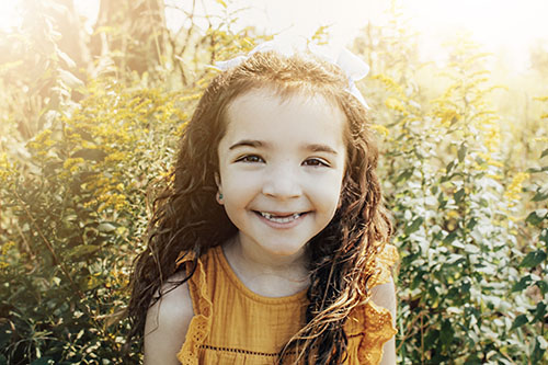 Girl in front of yellow flowers