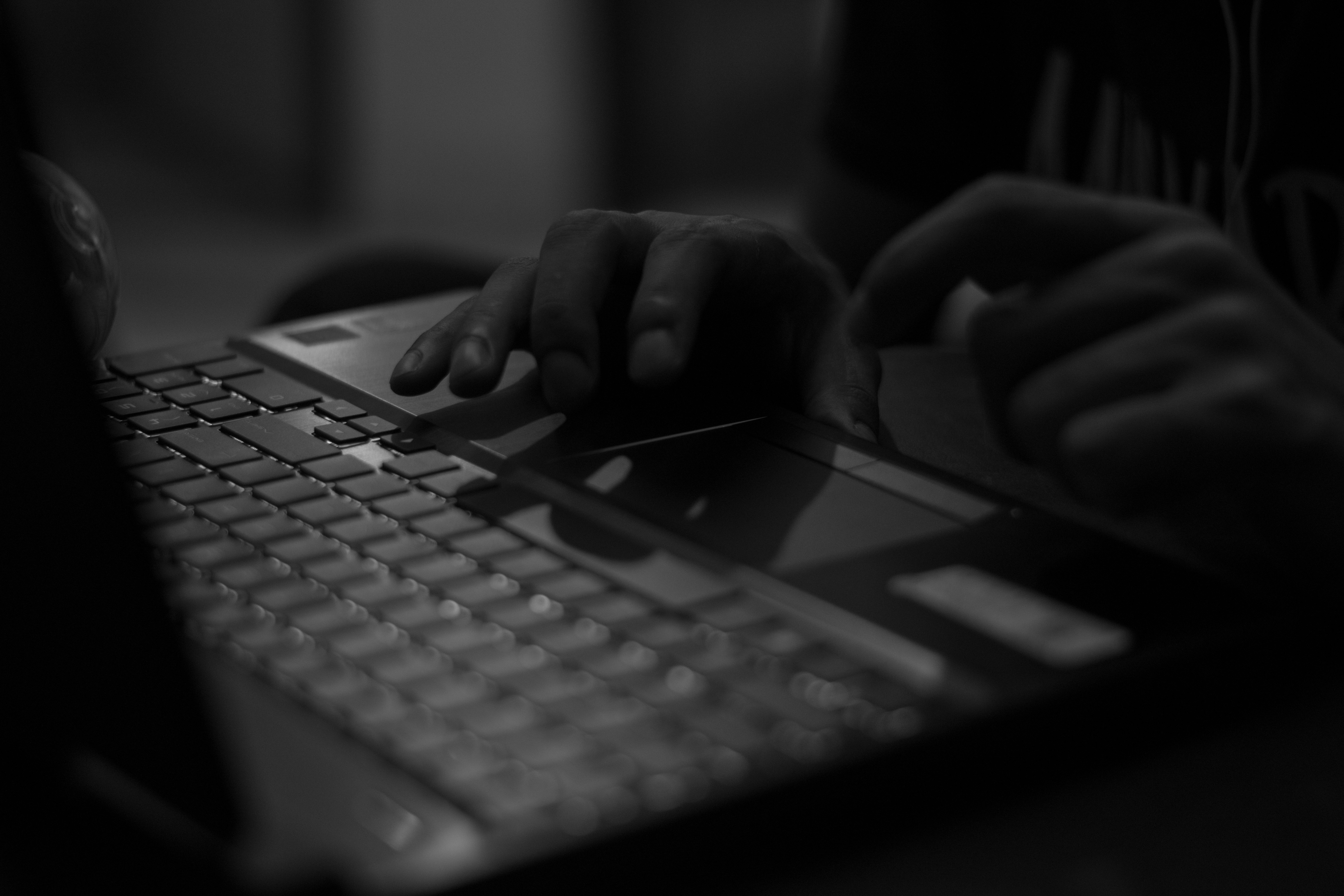 Picture of a person typing at a keyboard in grayscale