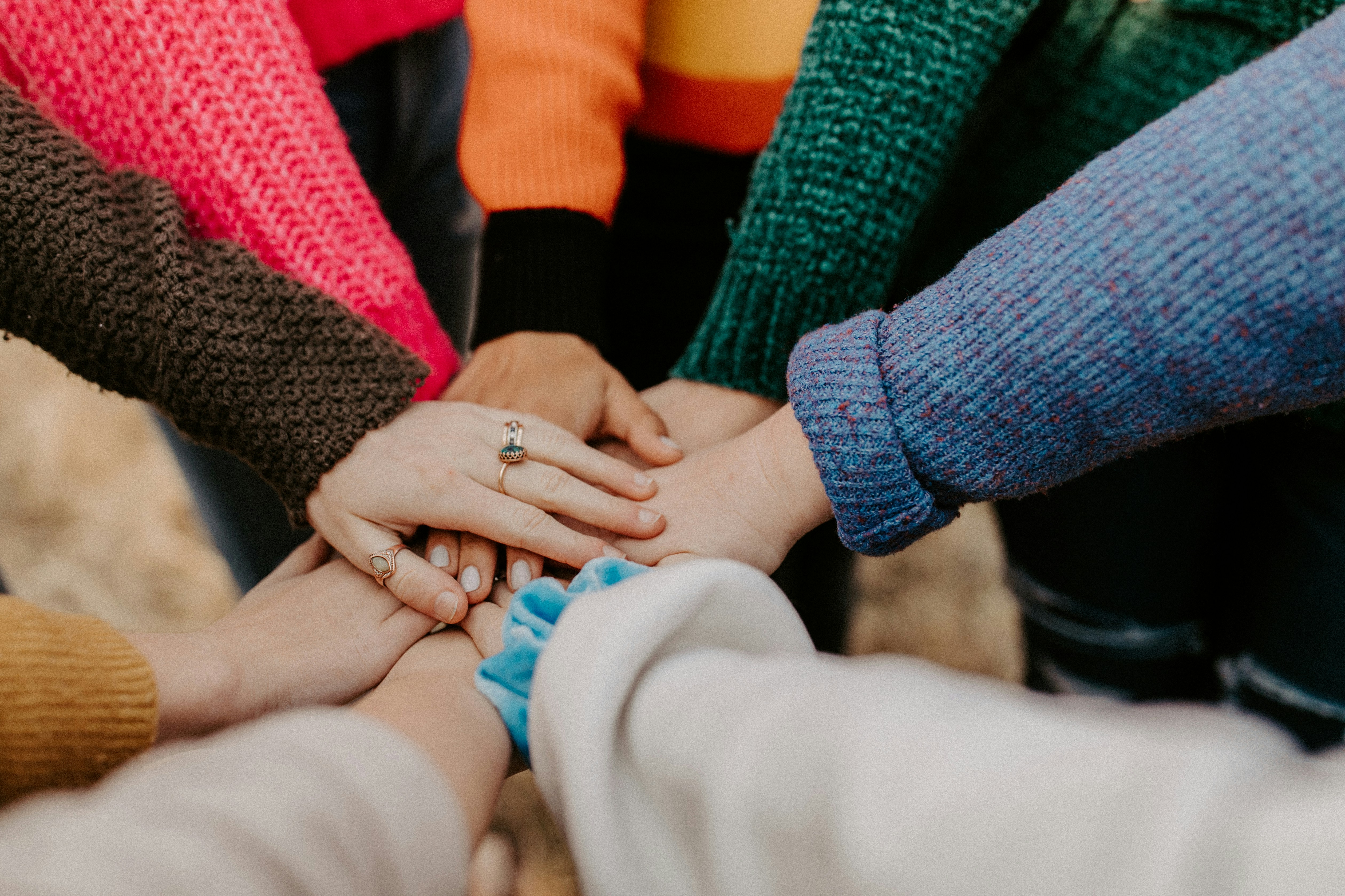 Photo of a group of people with their hands stacked together